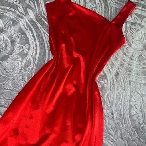 Red silk dress with slit on leg , knee length slit .